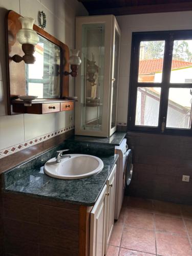 a bathroom with a sink and a mirror at Casa gallega Cedeira in Montojo
