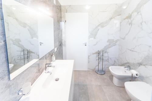 a white bathroom with a sink and a toilet at Dream Houses in Marina di Palma
