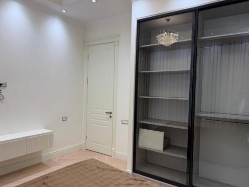 a room with a glass closet with a chandelier at Casa de prime in Baku