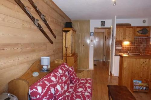a living room with a red couch and a table at Studio with mountain view in Barcelonnette in Barcelonnette