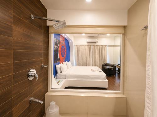 a bathroom with a bed and a shower with a mirror at Cosset - A Boutique Hotel in Lonavala
