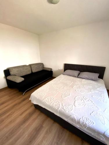 a bedroom with a bed and a couch at Stan na dan Harmonija in Nevesinje