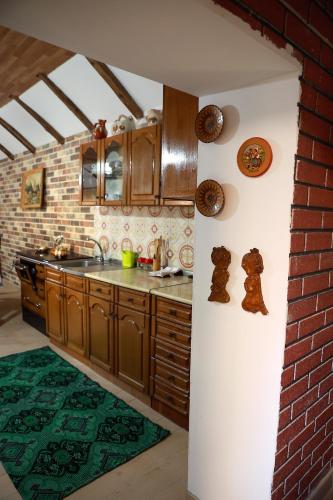 a kitchen with wooden cabinets and a brick wall at Sokolovic STD in Lapotince