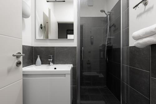 a white bathroom with a sink and a shower at Davin City Aparments - Self-Check-In in Hamburg