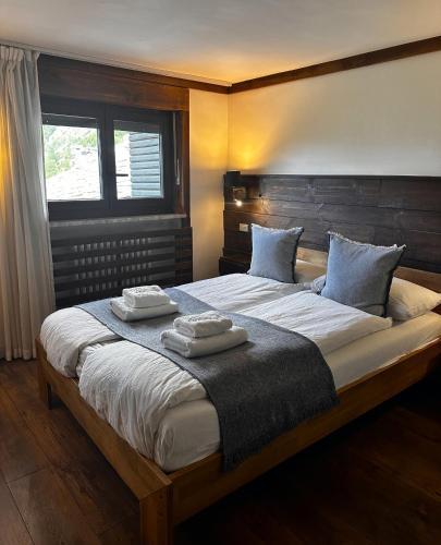 a bedroom with a large bed with two towels on it at Hotell Millefiori- Alpine Event Lodge in Valtournenche