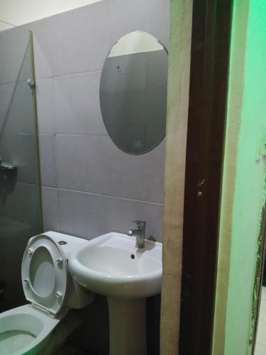 a bathroom with a toilet and a sink and a mirror at Light house hotel lekki phase 1 in Araromi