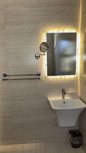 a bathroom with a white sink and a mirror at شقة أنيقة جديده في قلب أبها in Abha