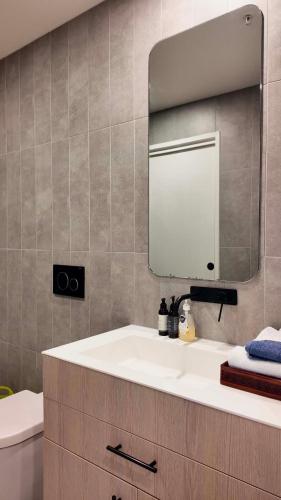 a bathroom with a white sink and a mirror at Premium Twin King Ensuites apartment with Double Sofa Bed at M-city Apartment Complex - Infinite Mountain View - Monash Uni & Hospital Clayton, 3168, Victoria, Australia - Free parking, Wifi, Amenities, Tea and Coffee in Clayton North