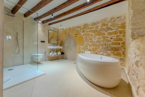 a bathroom with a large tub and a shower at Hotel Boutique Porta Ferrisa in Alicante