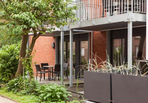 a patio with a table and chairs on a building at Wittehuus Wohnung 4 in Borkum