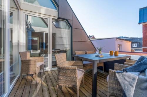 a patio with a table and chairs on a balcony at Wohnung K13 in Borkum