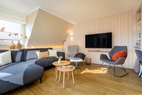 a living room with a blue couch and two chairs at Wohnung K13 in Borkum