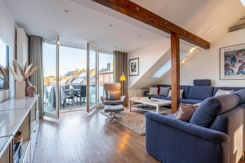 a living room with a blue couch and a table at Wohnung Strand Vier in Borkum