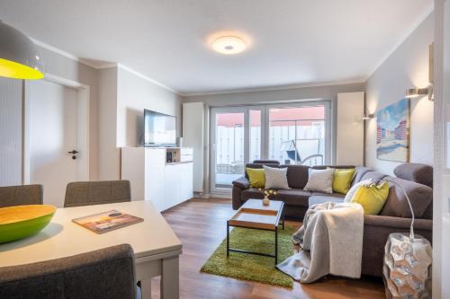 a living room with a couch and a table at Ferienwohnung Dwarslooper in Borkum