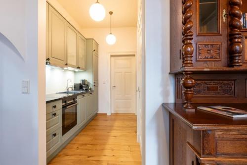 a kitchen with white cabinets and a wooden floor at Commandeur-Huus Wohnung 2 in Borkum