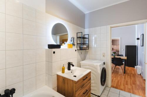 a bathroom with a sink and a washing machine at Altstadt Suite in Freiberg