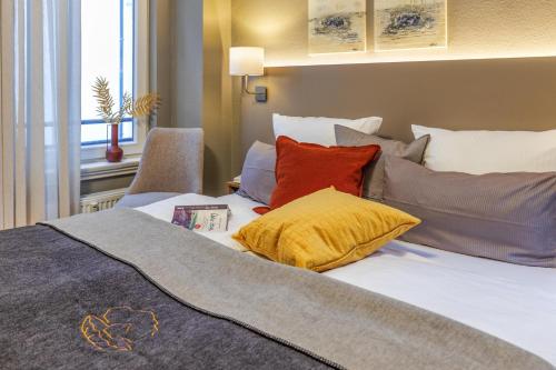 a bed with colorful pillows on top of it at Ferienwohnung Eilert in Borkum