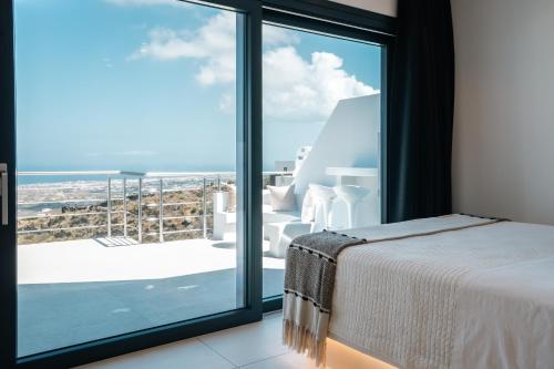 a bedroom with a bed and a view of the ocean at Lackos Luxury Suites in Imerovigli