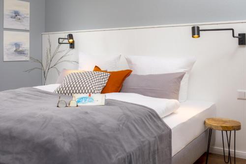 a bedroom with a large bed with grey and orange pillows at Ferienwohnung Villa Central - Lüttje Nüst in Borkum