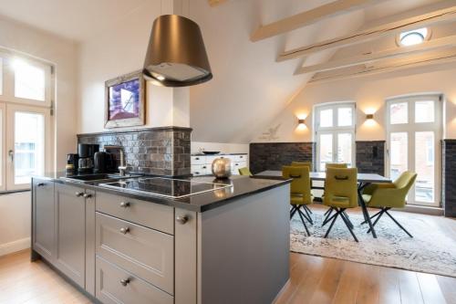 a kitchen with a stove and a table with chairs at Commandeur-Huus Wohnung 3 in Borkum
