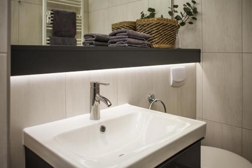 a bathroom with a white sink and a mirror at Ferienwohnung Villa Central - Lüttje Nüst in Borkum