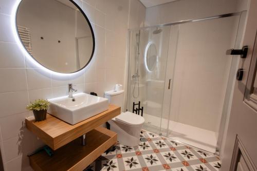 a bathroom with a sink and a toilet and a mirror at Darm in Lamego