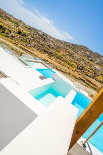 a view of the infinity pool from the balcony of a house at Legendary Suites in Mikonos