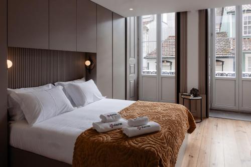 a bedroom with a large bed with two towels on it at Darm in Lamego