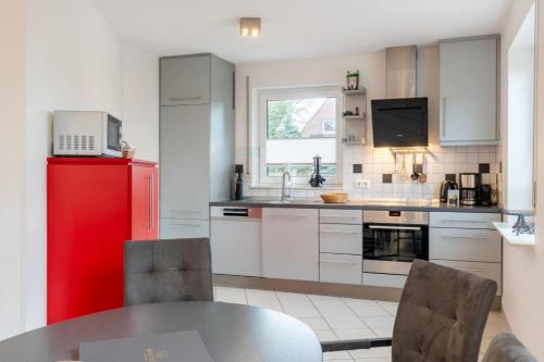 a kitchen with a red refrigerator and a table at Haus Stranddüne in Borkum