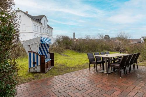 a patio with a table and chairs and a house at Haus Stranddüne in Borkum