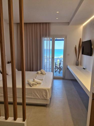 a bedroom with a bed and a view of the ocean at Villa Maniati Chrissi Ammos in Agios Petros