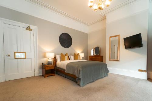 a bedroom with a bed and a tv on the wall at Farington Lodge Hotel in Preston