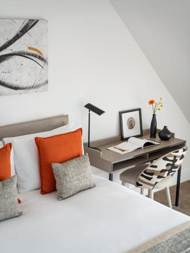 a bedroom with a desk and a bed with orange pillows at Micklegate by Supercity Aparthotels in York