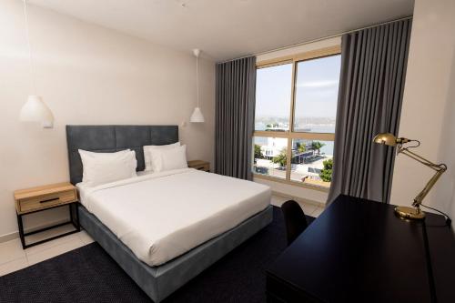 a hotel room with a bed and a large window at Almar Aparthotel in Lobito