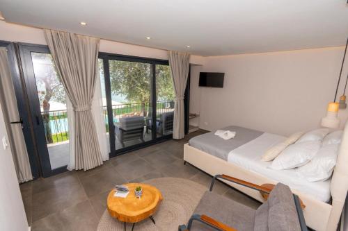 a bedroom with a bed and a table and a balcony at The Olive Garden in Shkodër