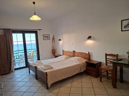 a bedroom with a bed and a view of the ocean at Valeta Studios in Armenistis