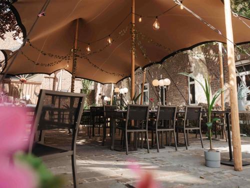 a table and chairs under a large umbrella at Blooma Hotel Liege Centre - Accor Handwritten Collection in Liège