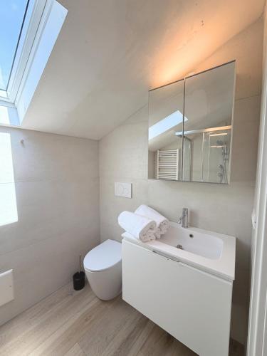 a white bathroom with a toilet and a sink at Casa Historia in Caorle