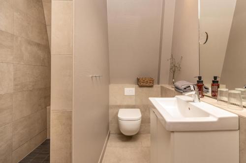 a white bathroom with a toilet and a sink at Logierhaus K15 Appartement 10 in Borkum