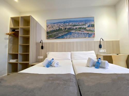 a bedroom with two beds with white sheets at Hostal BESTPRICE Barcelona Stadium in Barcelona