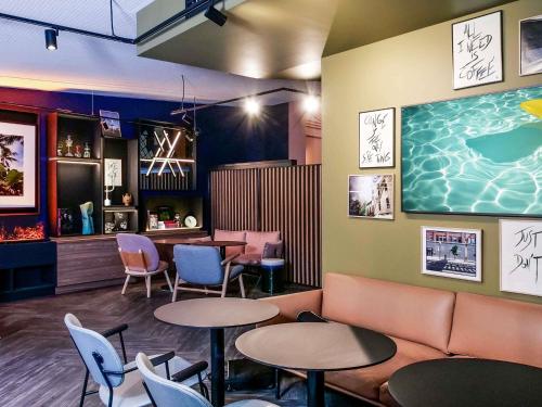 a restaurant with tables and chairs and a bar at TRIBE Paris Batignolles in Paris