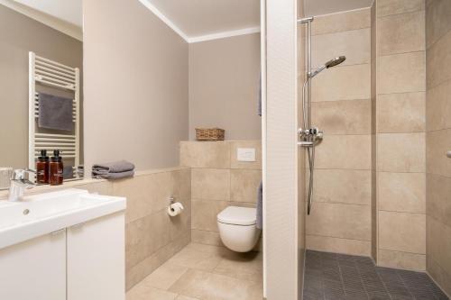 a bathroom with a shower and a toilet and a sink at Logierhaus K15 Appartement 5 in Borkum
