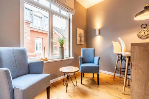 a living room with chairs and a window at Logierhaus K15 Appartement 4 Plus in Borkum