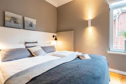 a bedroom with a large bed with a blue rug at Logierhaus K15 Appartement 4 Plus in Borkum