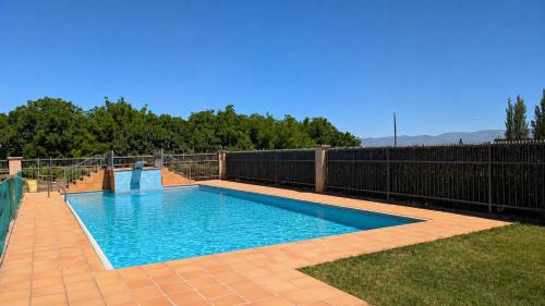 a swimming pool in a yard next to a fence at Chalet en La Rioja para familias y grupos in Tricio