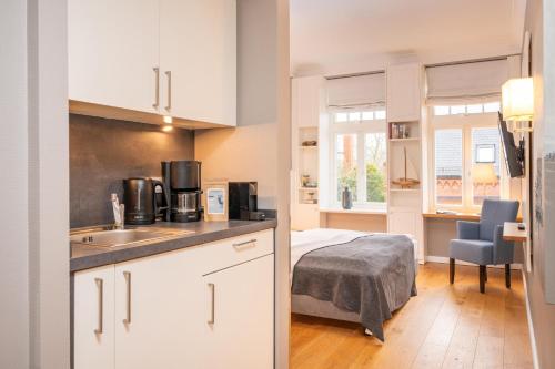 a kitchen with a sink and a bed in a room at Logierhaus K15 Appartement 8 in Borkum