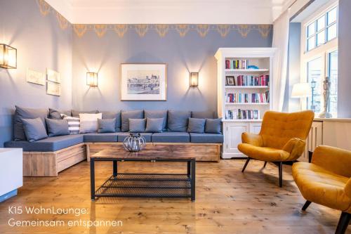 a living room with a blue couch and a coffee table at Logierhaus K15 Appartement 8 in Borkum