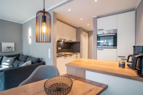 a kitchen and living room with a couch and a table at Ferienwohnung Deck7 in Borkum