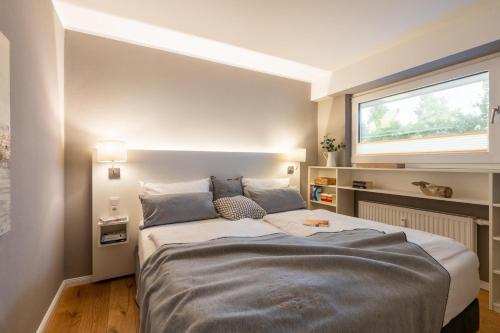 a bedroom with a large bed with a window at Ferienwohnung Deck7 in Borkum