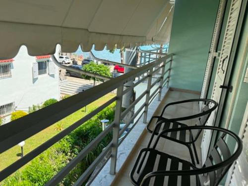 a balcony with two chairs and a view of the ocean at Sea Opera A4 in Kamena Vourla